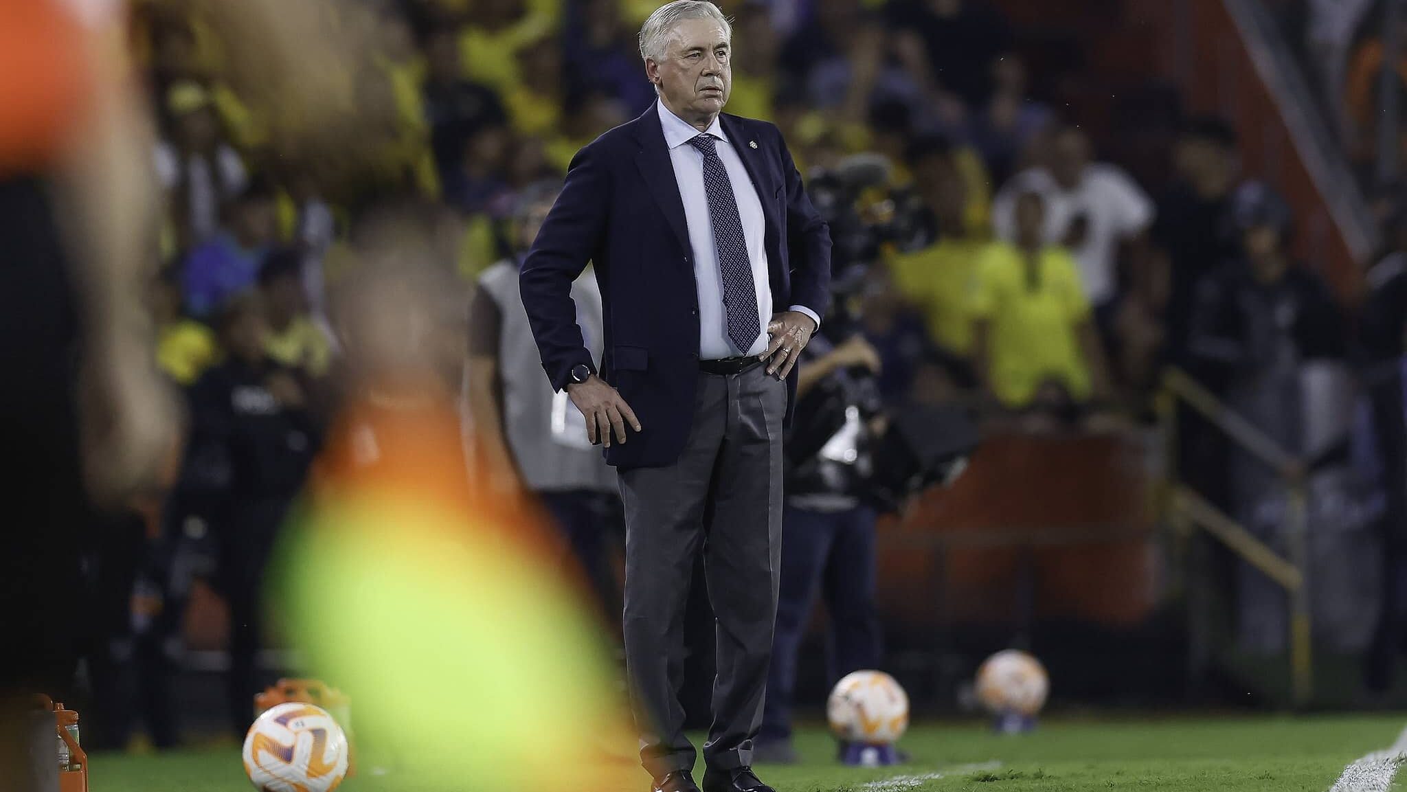 Ancelotti com a mão na cintura na beira do gramado